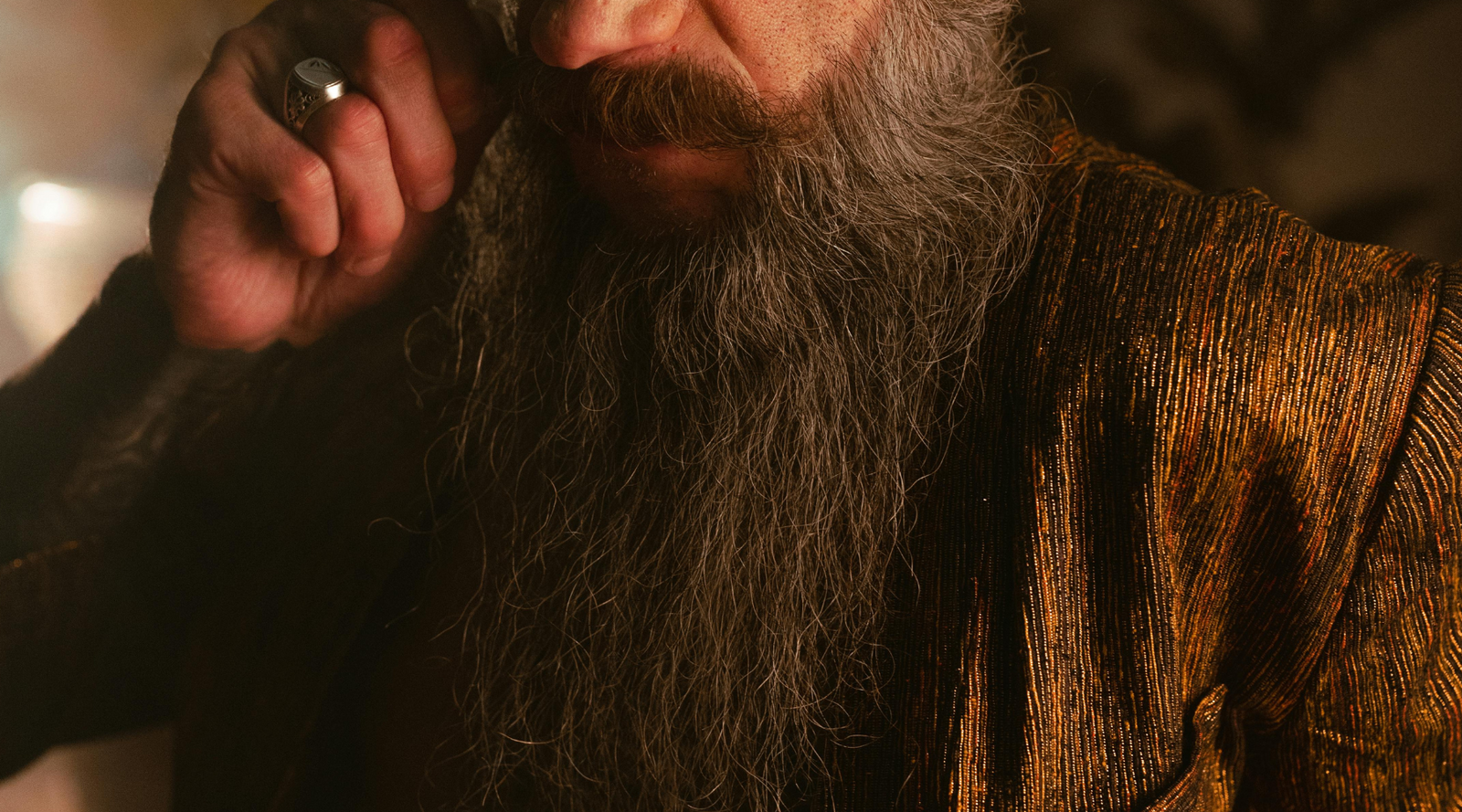 A rugged, well-groomed man with a full, thick beard, representing the benefits of proper beard care and styling using Mammoth Beard Co. products.