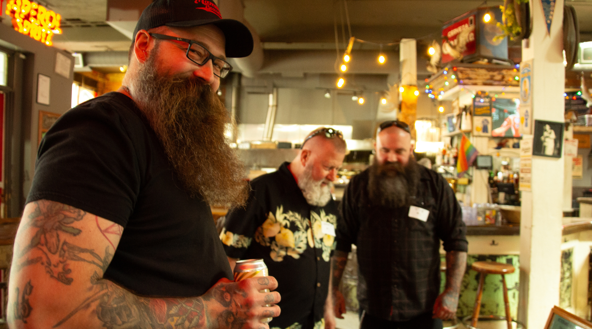Three bearded men standing in The Palomimo Smokehouse for the Alberta Beard and Moustache Competition 