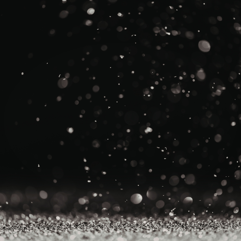Snowfall effect on a black background with a silver glittery line at the bottom representing beard dandruff