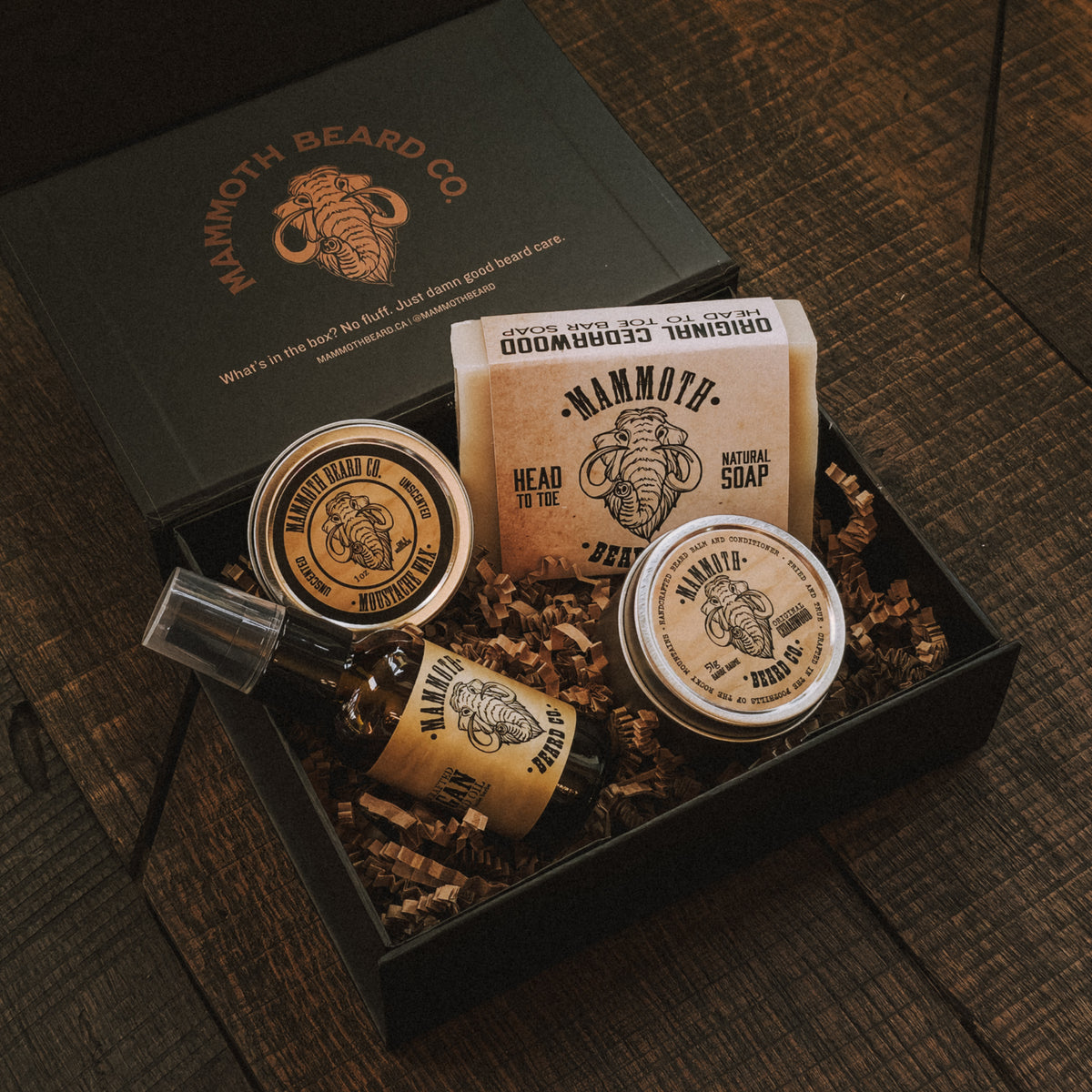 Mammoth Beard Co. grooming products in a box on a wooden surface