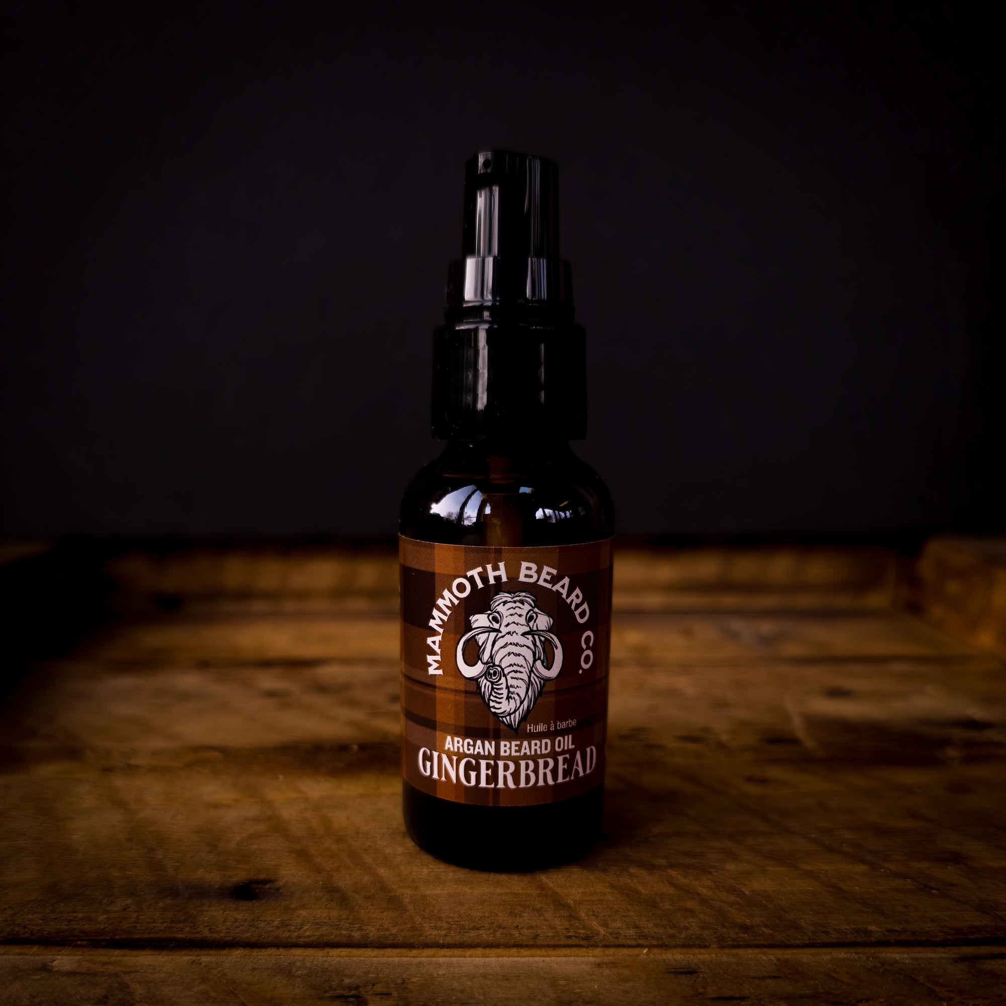Mammoth Beard Co Gingerbread Argan Beard Oil bottle with brown plaid label on wooden background, warm spicy holiday scent