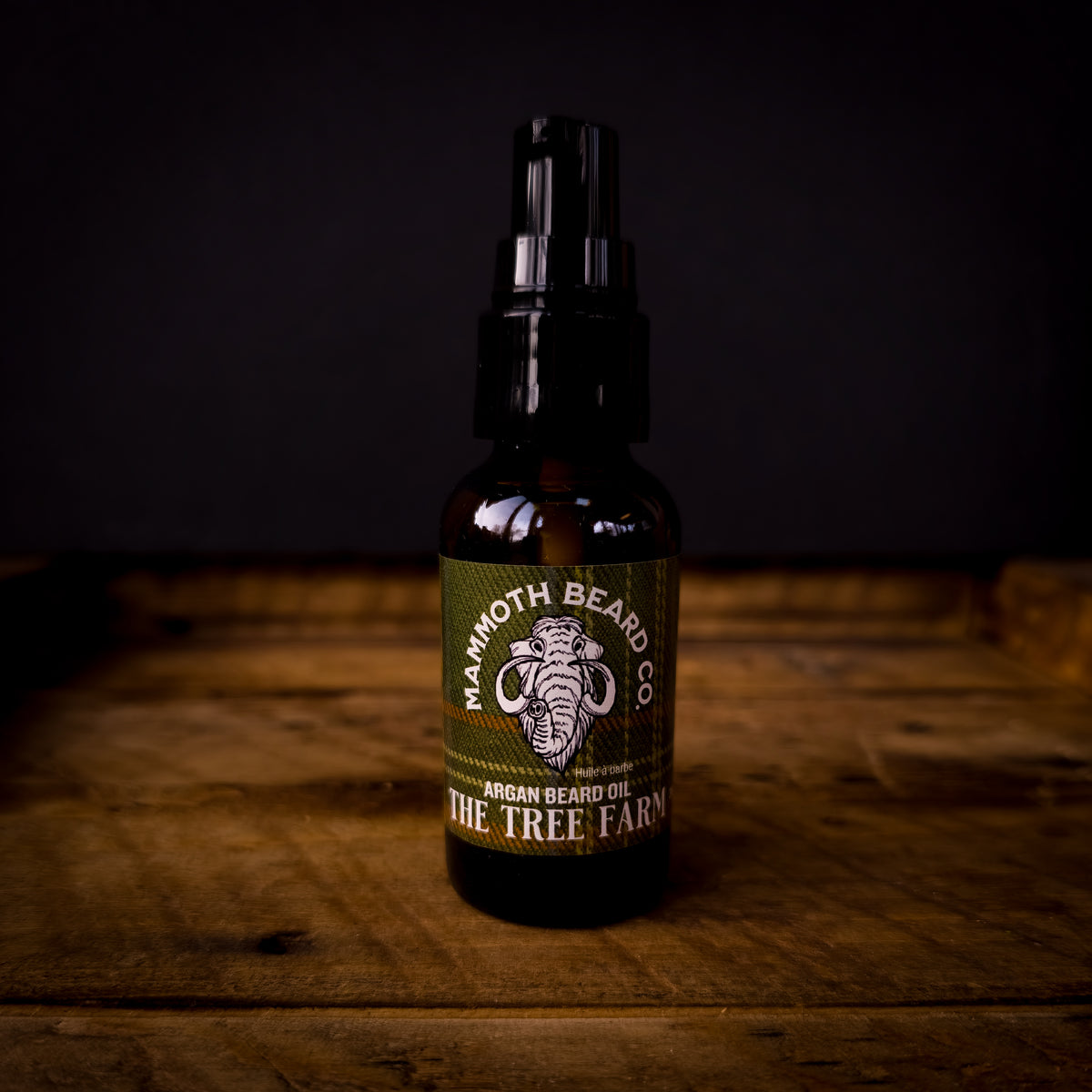 Mammoth Beard Co The Tree Farm Argan Beard Oil bottle with green plaid label on rustic wood, fresh evergreen Christmas scent