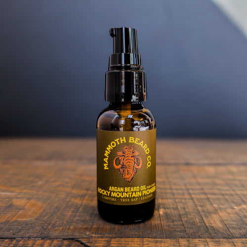 Mammoth Beard Co. argan beard oil bottle on a wooden surface with a dark background
