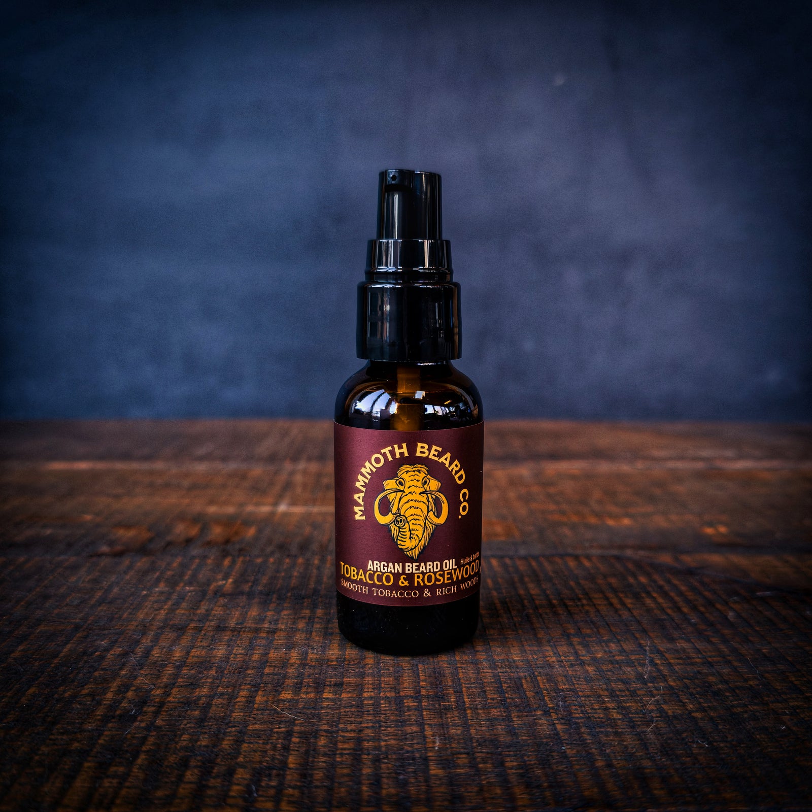 Mammoth Beard Co Tobacco & Rosewood argan beard oil bottle on rustic wood surface, premium all natural beard oil for conditioning and softening beard hair